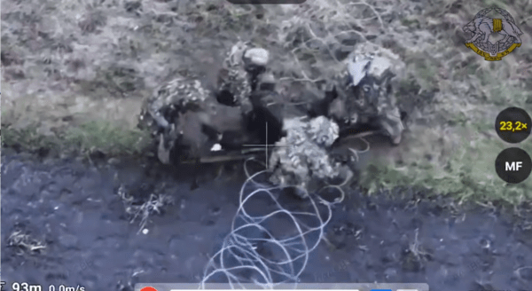 우크라이나 특수작전군 사령부 산하 84 전술여단 병사 여러 명이 부상한 북한군 병사를 들고 철조망을 빠져나가는 모습/텔레그램 캡처