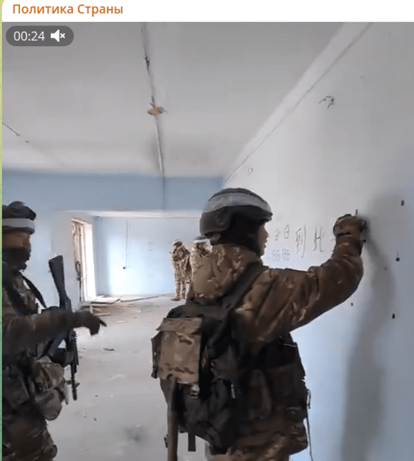 포크로프스크 전투 영상에 잡힌 중국인. 러시아 군복 차림으로 벽에 한자로 뭔가를 적고 있다/영상 캡처