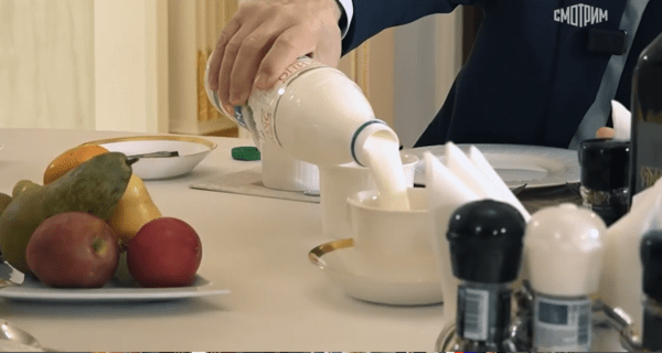 과일과 간장, 후추, 냅킨 등이 있는 식당 식탁에 앉아 기자의 컵에 케피르를 따라주고 있다.&nbsp;&nbsp;