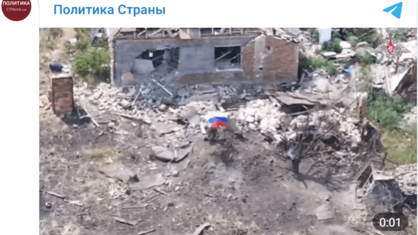 포크로프스크의 파괴된 잔해 속에 러시아 군인이 국기를 펼치고 있는 모습/영상 캡처